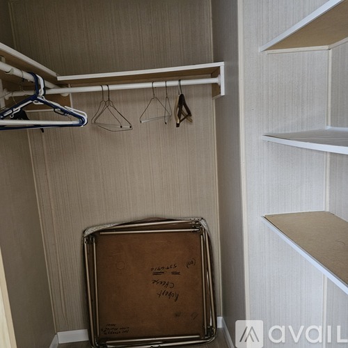 A suitcase with the word "Luggage" written on it is sitting on a shelf in a closet.