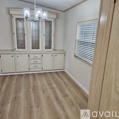A room with wooden flooring and a chandelier.
