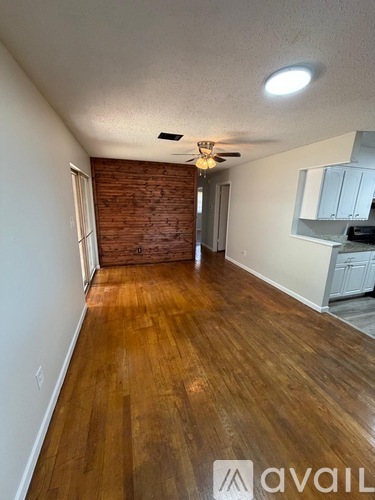 A room with wooden floors and a brick wall.