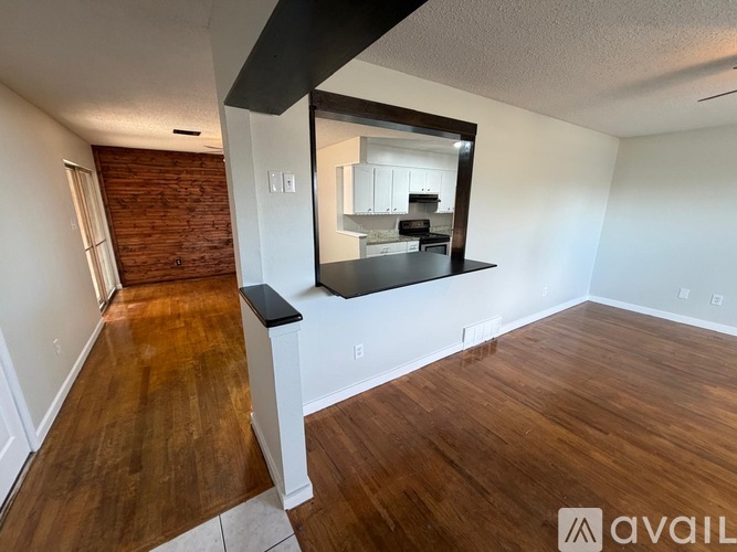 A room with wooden floors and a mirror on the wall.