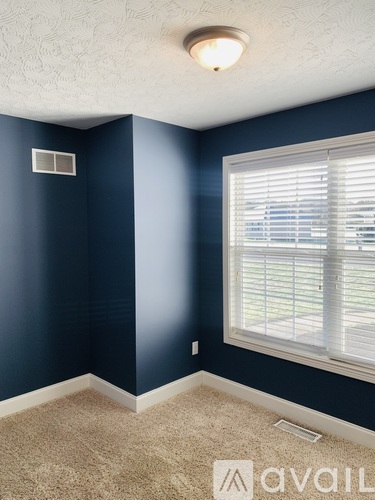 A room with blue walls and a window with blinds.