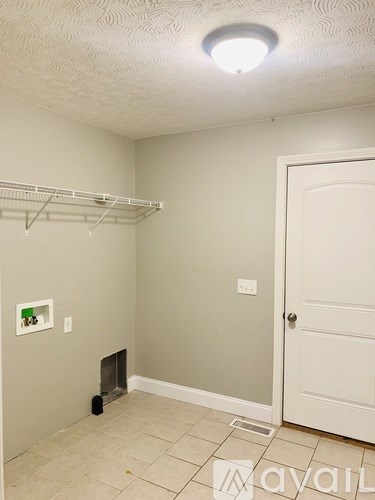 A room with a white door and a grey wall.