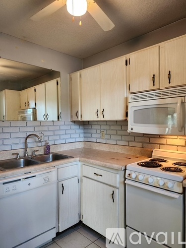 A kitchen with white appliances and cabinets.