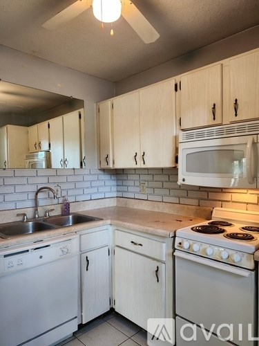 A kitchen with white appliances and cabinets.