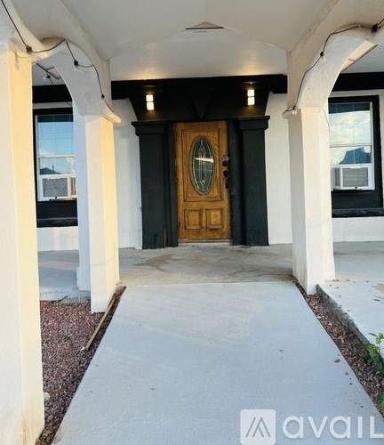 A brown door is flanked by two white columns.