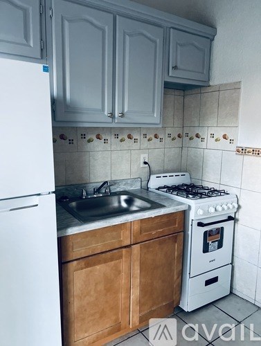 A kitchen with a white refrigerator, a white stove, and wooden cabinets.