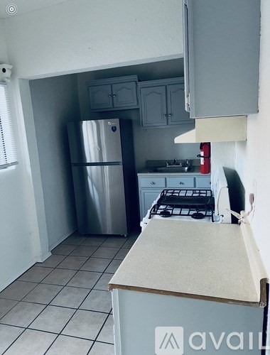 A kitchen with a stainless steel refrigerator and a white stove top oven.