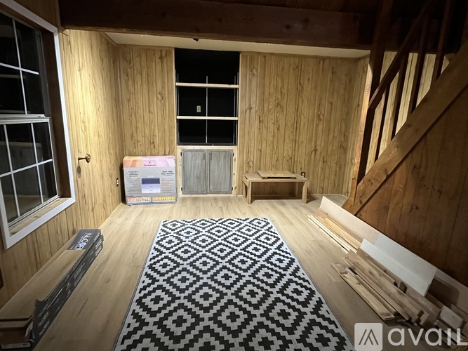 A room with wooden walls and a black and white patterned rug.