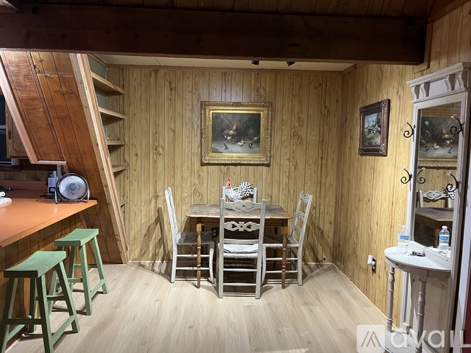 A wooden room with a table and chairs.