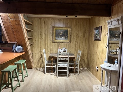 A wooden room with a table and chairs.