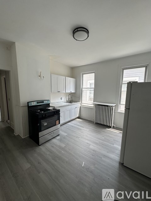 A kitchen with a black stove top oven and a grey refrigerator.