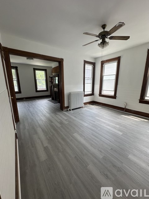 A room with a ceiling fan and wooden flooring.