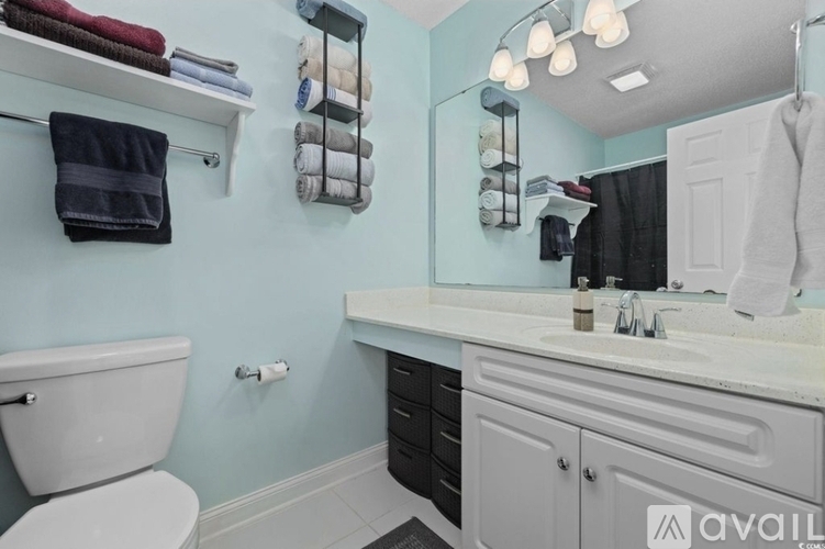 A bathroom with a toilet, sink, and towel rack.