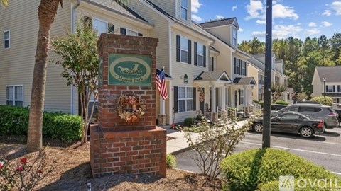A brick pillar with a sign that says "AVAILABLE" in front of a building.