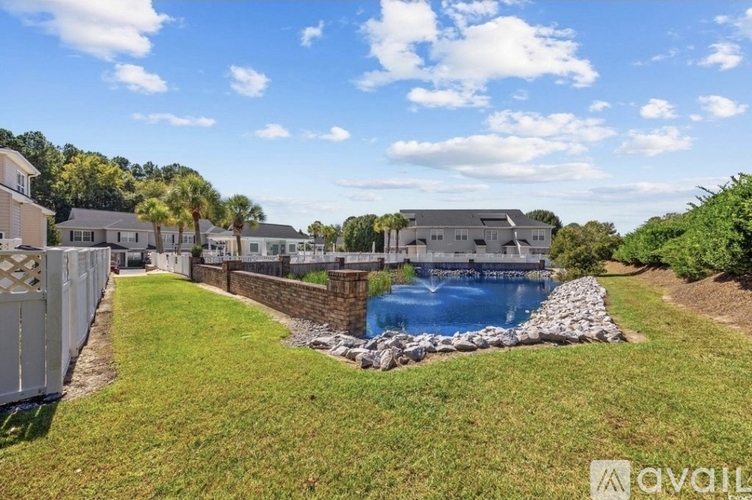 A backyard with a blue pool and a white fence.