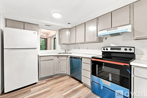 A kitchen with white appliances and wooden floors.