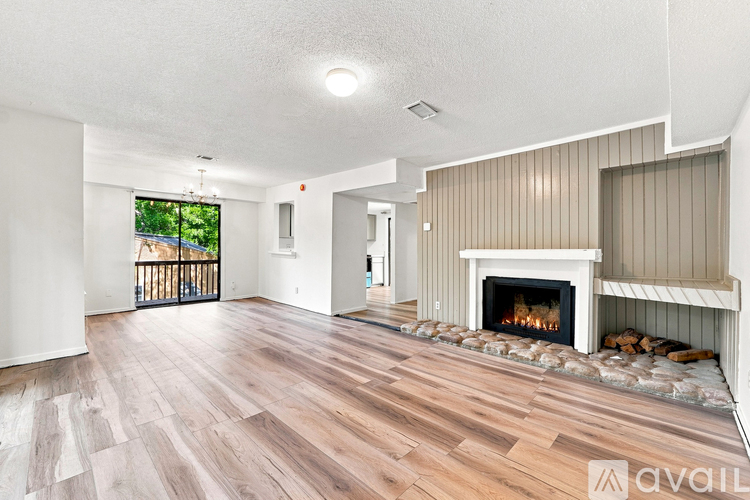 A living room with a fireplace and wood flooring.