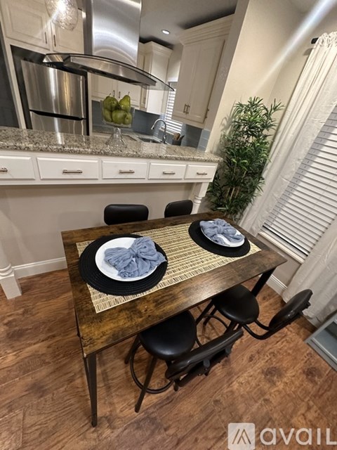 A dining table with two plates and a napkin on it.