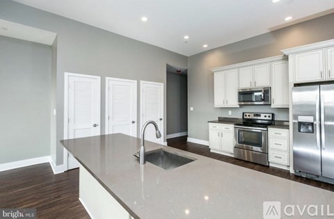 A kitchen with a stainless steel refrigerator, microwave, oven, and sink.