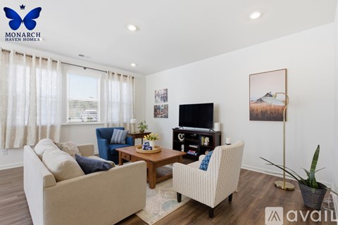 A living room with a couch, chair, and television.