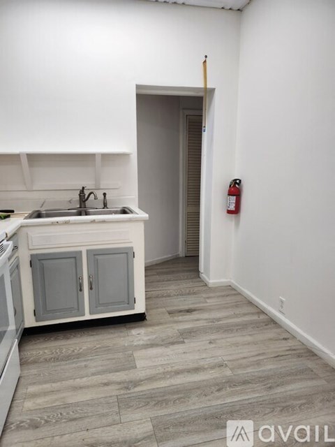 A kitchen with a sink and a fire extinguisher on the wall.