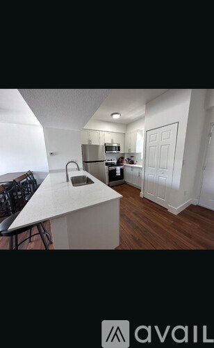 A kitchen with a white countertop and a refrigerator in the background.