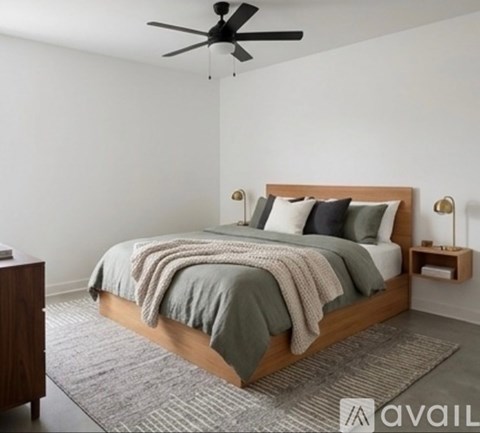 A bedroom with a bed, pillows, a blanket, a ceiling fan, and a nightstand.