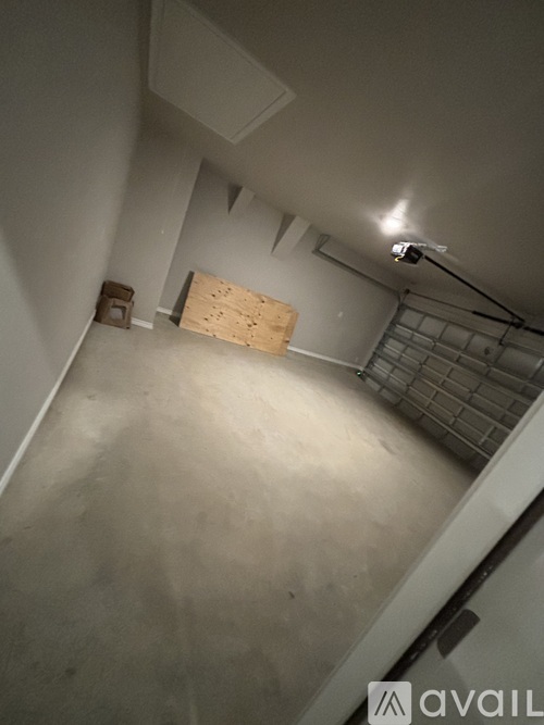 A room with a white wall and a wooden door.