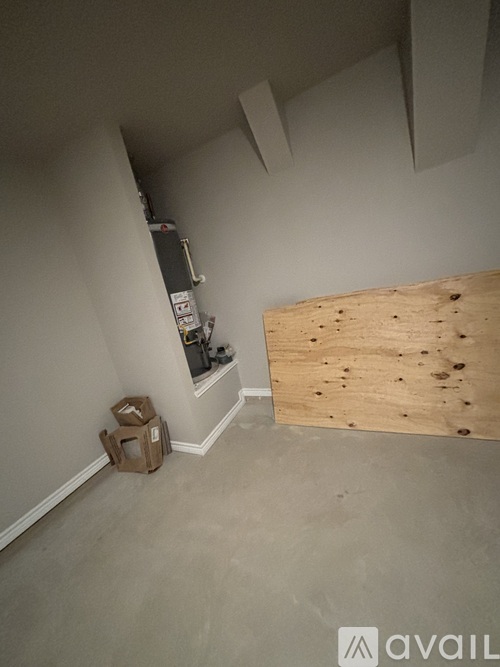 A room with a wooden board on the wall and a fire extinguisher on the left.
