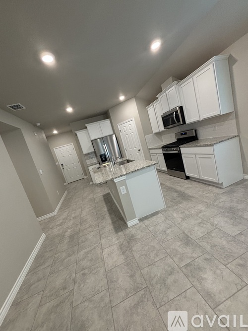 A kitchen with white cabinets and a tiled floor.