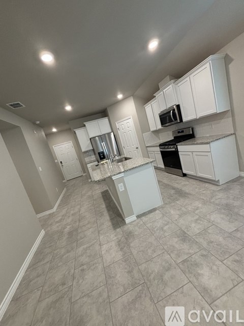 A kitchen with white cabinets and a tiled floor.