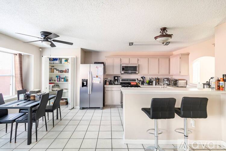 A kitchen with a table and chairs.