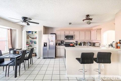 A kitchen with a table and chairs.