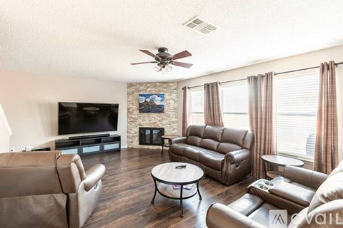 A living room with brown leather furniture and a flat screen TV.
