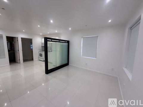 A spacious room with a glass door and a white floor.