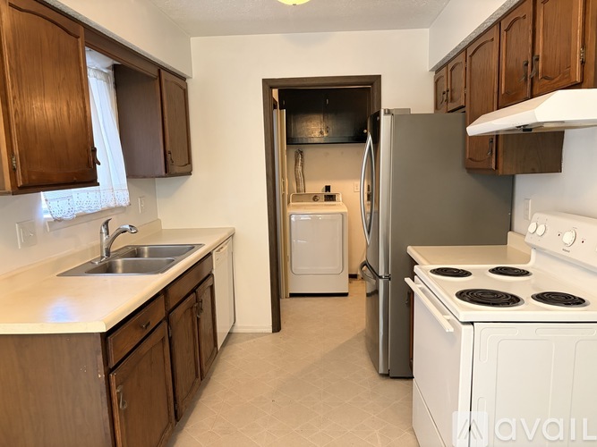 A kitchen with a white stove and a white sink.
