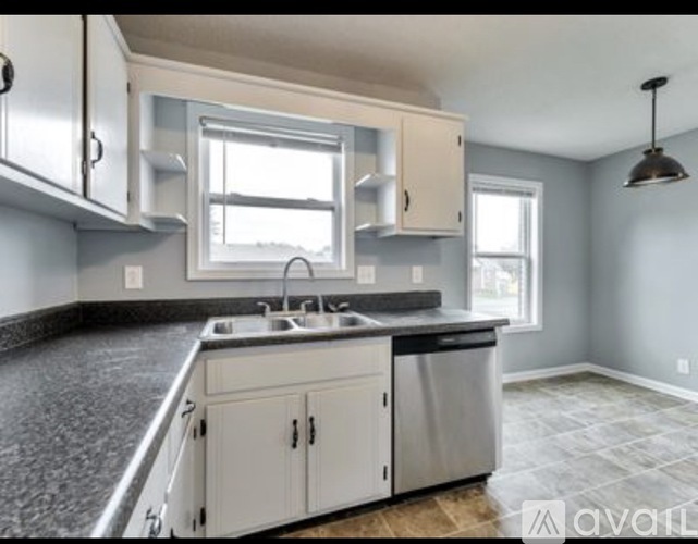 A kitchen with white cabinets and a granite countertop.
