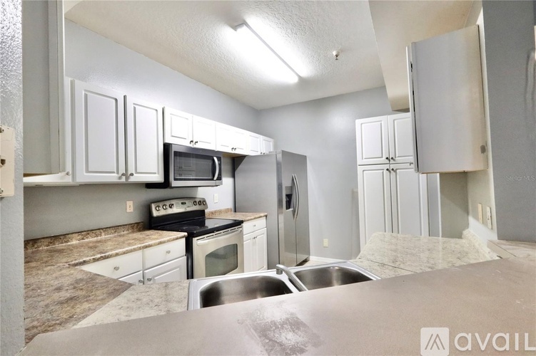 A kitchen with white cabinets and stainless steel appliances.