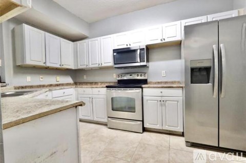 A kitchen with white cabinets and stainless steel appliances.