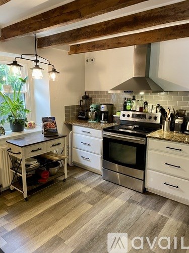 A kitchen with white cabinets and a wooden ceiling.