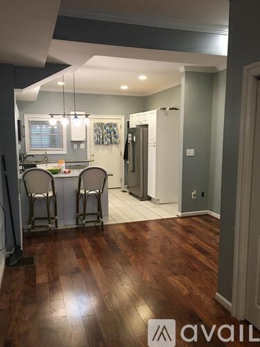 A kitchen with wooden floors and a dining table with chairs.
