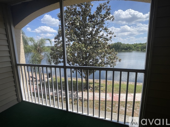 A view from a balcony looking out at a lake and trees.