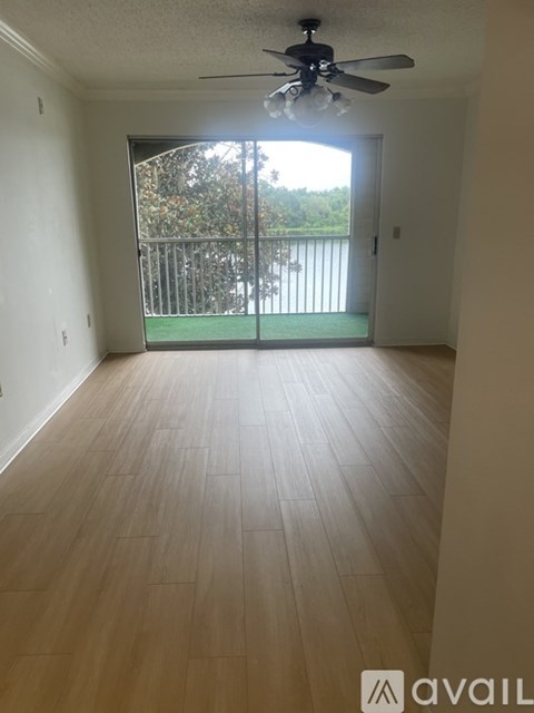 A room with a ceiling fan and wooden flooring.