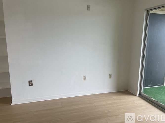 A room with a white wall and wooden floor.