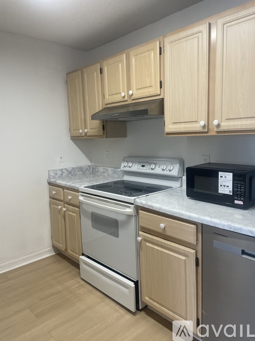 A kitchen with wooden cabinets and a white countertop.