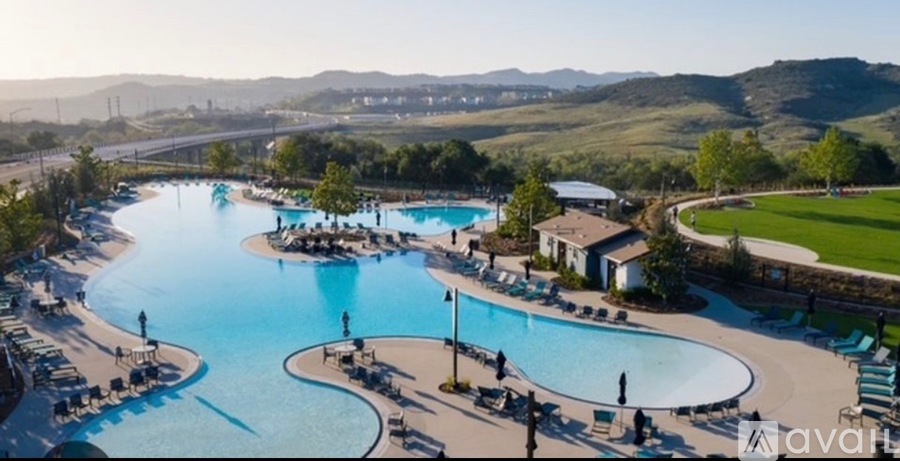 A large outdoor swimming pool with people in it.
