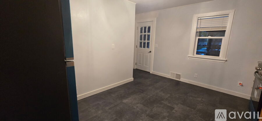 A room with a window and a door is available for rent.