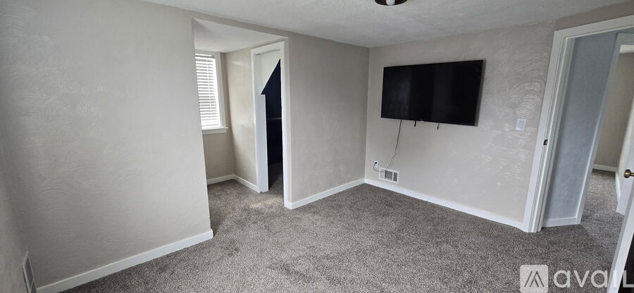 A living room with a flat screen TV mounted on the wall.