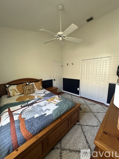 A bedroom with a bed and a ceiling fan.