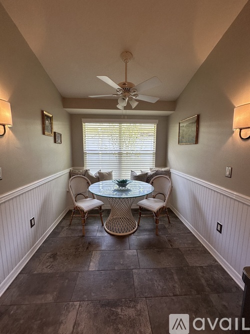 A dining room with a table and chairs.